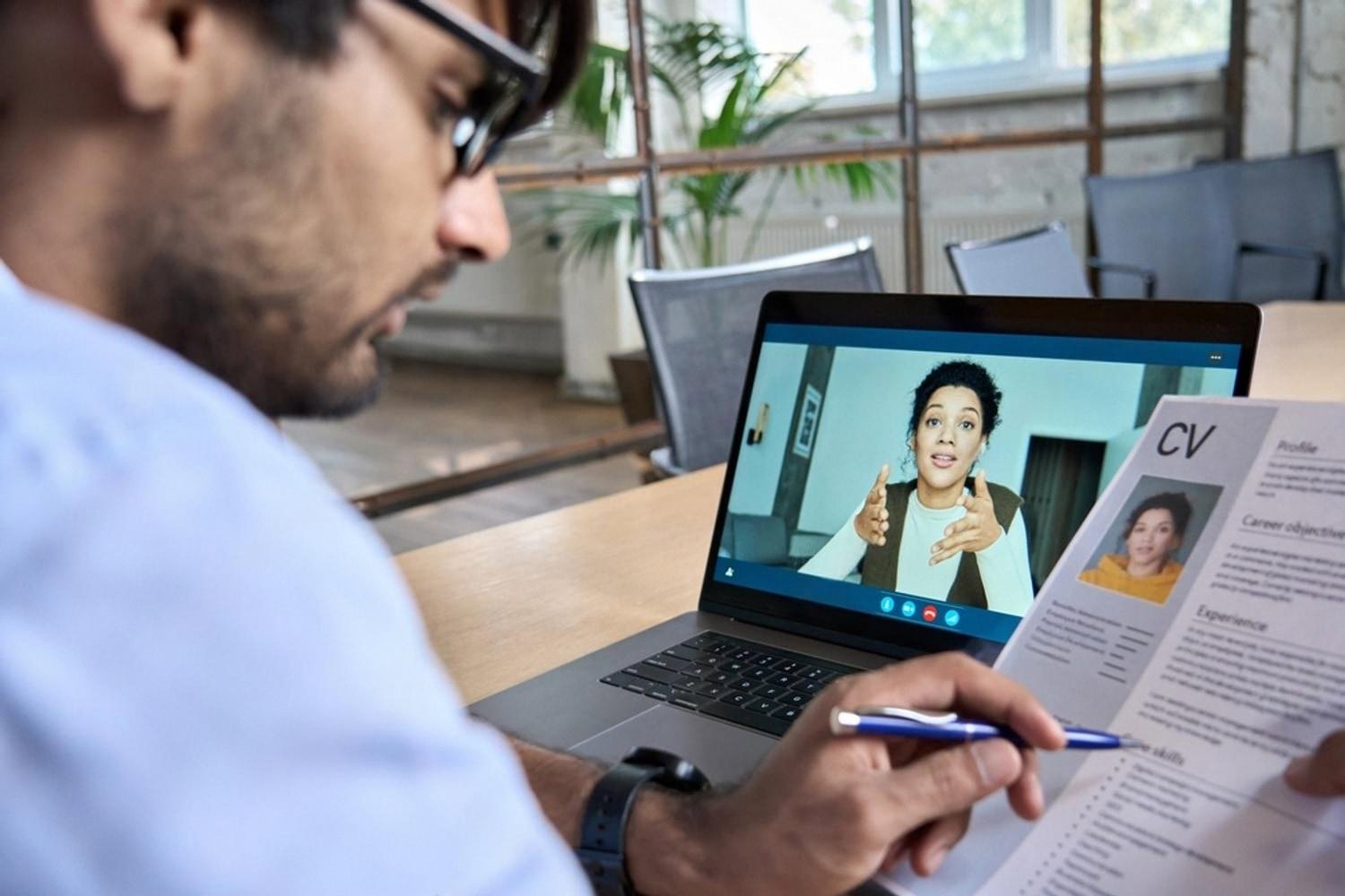 Hiring manager reviewing a CV during a video interview with a remote candidate